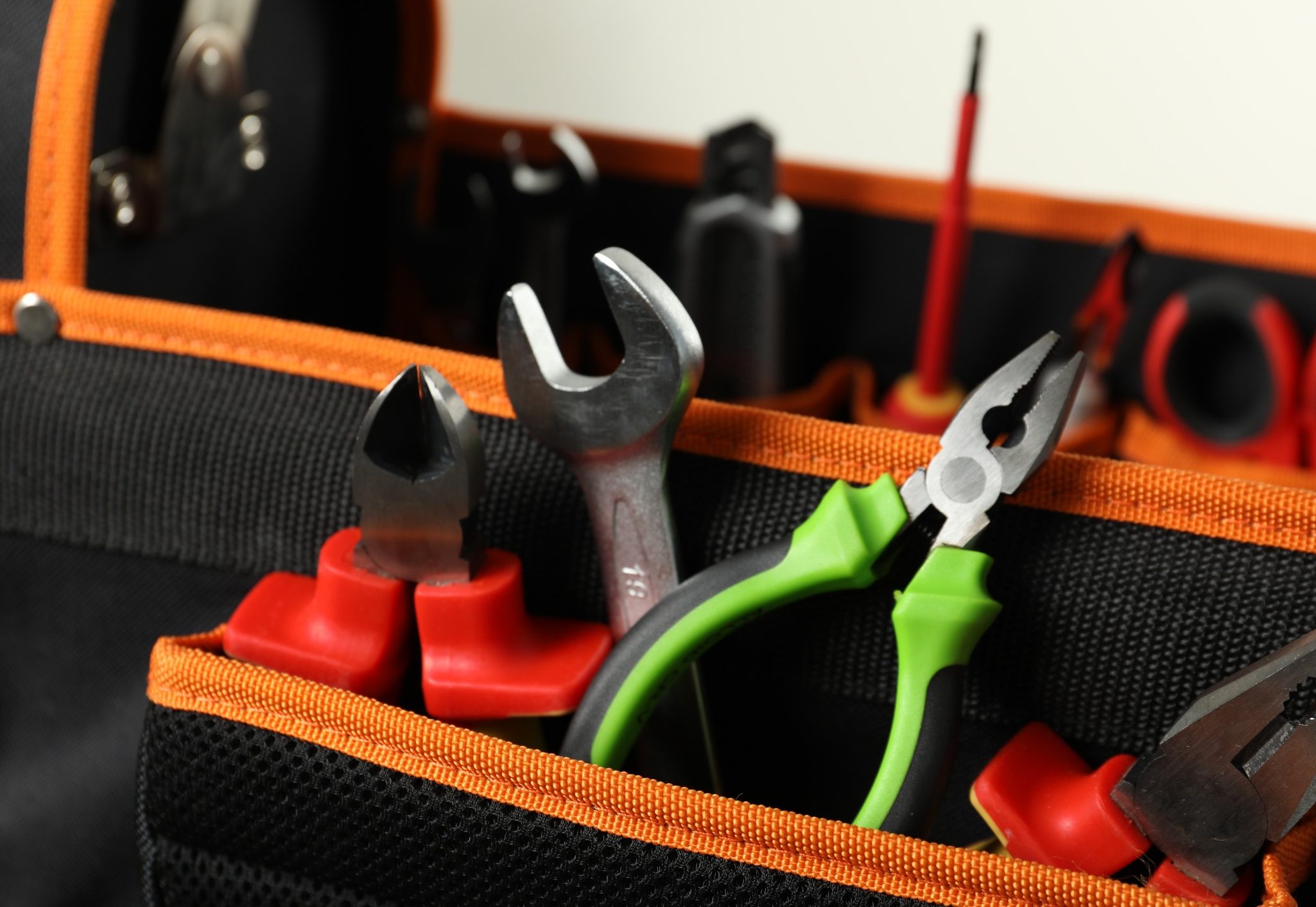Bag with different pliers, wrench and other tools for repair, closeup